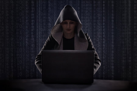 masked hacker against digital code background using smartphone opposite digital code background. Hacking the Internet.の写真素材