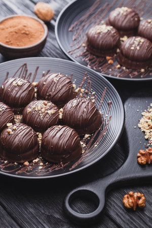 delicious mini chocolate cakes with walnut on a black wooden tableの写真素材