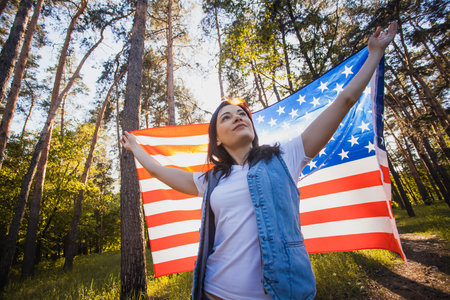 happy smiling young woman with national american flag outdoors