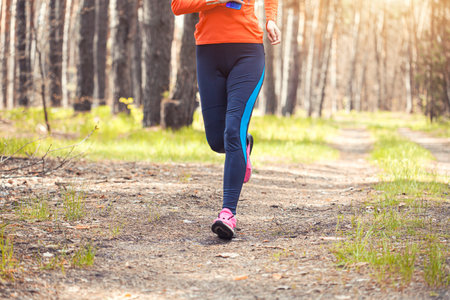 women athlete running through the woods. Feet, bottom viewの写真素材