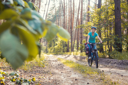 mother with small baby on bicycle. Family biking in the summer pine forestの写真素材