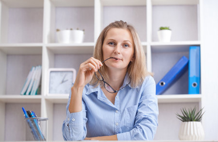 tired businesswoman sitting in a chair at her working place.の写真素材