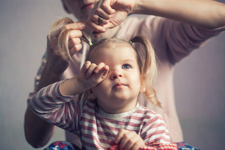 Mom braids her little daughters hairの写真素材