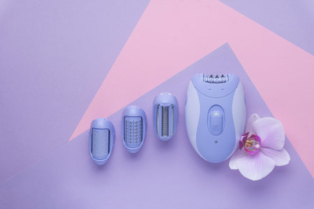 top view of Modern epilator on purple background. skin care, removal of unwanted hair.
