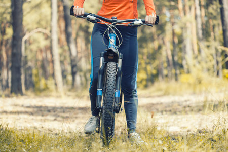 woman cyclist rides in the forest on a mountain bike.