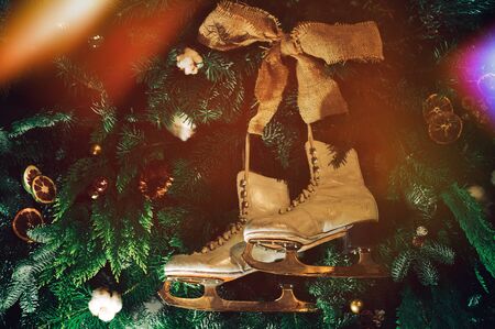 vintage old white ice skates hanging on decorated Christmas trees as toysの写真素材