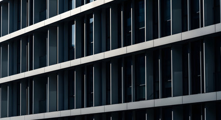 A close-up view of a contemporary office buildings exterior, showcasing a pattern of dark windows and light-colored horizontal architectural elements.の素材