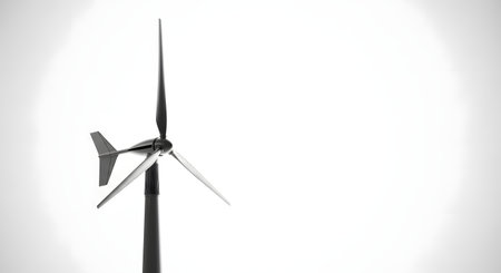 A close-up, low-angle shot of a modern wind turbine with its blades extended, set against a bright, overcast sky. The turbine is a symbol of renewable energy and sustainability.の素材