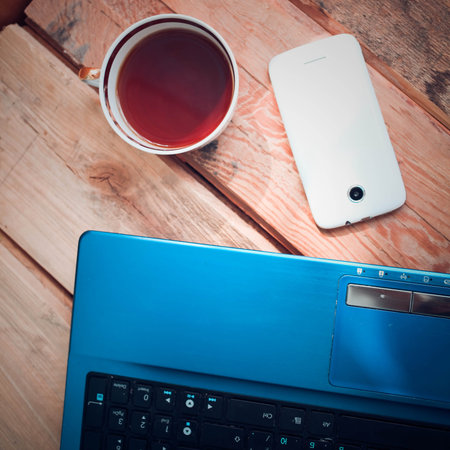 Laptop with mobile phone and coffee cupの写真素材