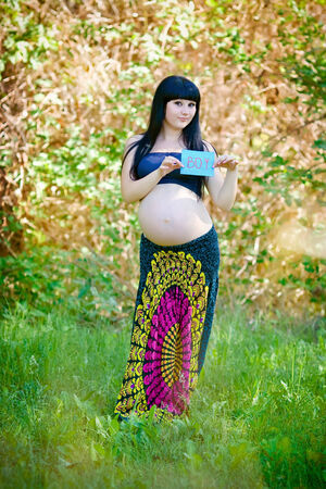 Beautiful pregnant woman relaxing in the parkの写真素材