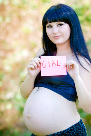 Beautiful pregnant woman relaxing in the parkの写真素材