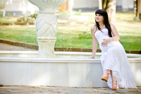 Beautiful pregnant woman relaxing in the parkの写真素材