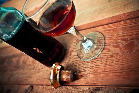 bottle and glass of cognac with ice on a wooden backgroundの写真素材