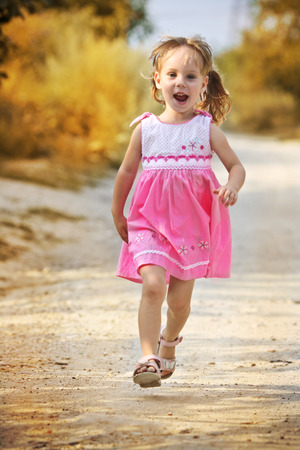 running open arms little happy girl green meadow field trackの写真素材
