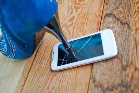 High heel shoe crushing a mobile phone.の写真素材