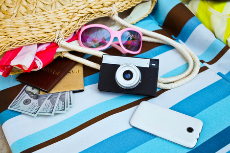 Female tourist accessories: cover, sunglasses, straw bag, passport, money and camera. Summer conceptの写真素材