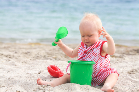 Baby playing on the sandy beach near the seaの写真素材