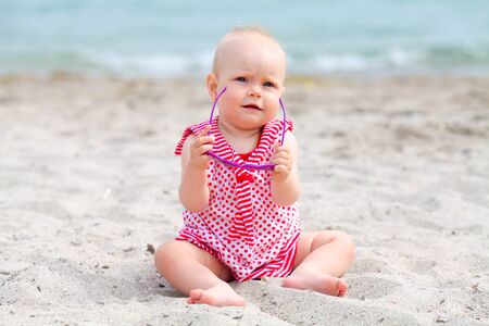 The little girl sits on a beachの写真素材