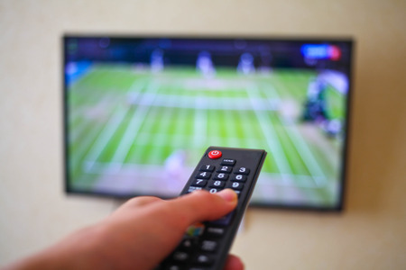 Men with the remote control, front of the television.の写真素材
