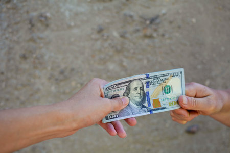 Female hands giving dollars.Shallow focus.の写真素材