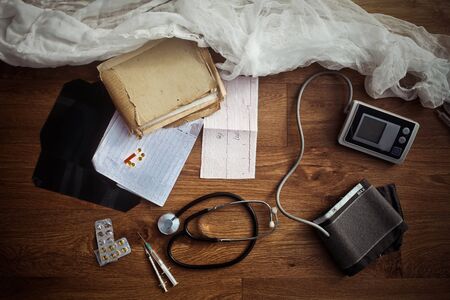 working elements of blood pressure monitor and stethoscope on vintage wooden board horizontal version medical conceptの写真素材
