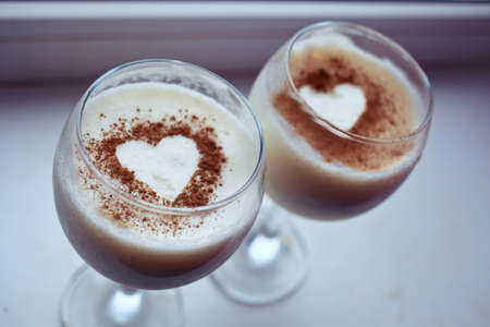Close up two milk desserts with the image of heartの写真素材