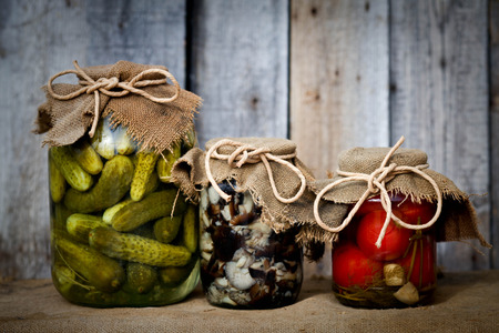 Jars with pickled vegetables on wooden backgroundの写真素材
