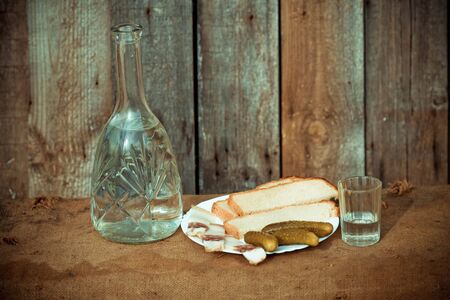 Vodka decanter, and snack (fat, bread and pickle) in the Ukrainian styleの写真素材