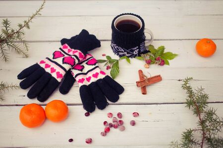 Gloves, cup of coffee on a white wooden backgroundの写真素材