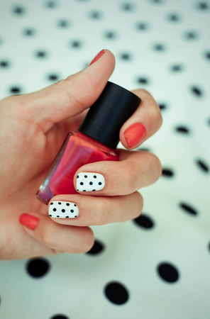 Manicure - Beauty treatment photo of nice manicured woman fingernails. Very nice feminine nail art with nice red, white and black nail polishの写真素材