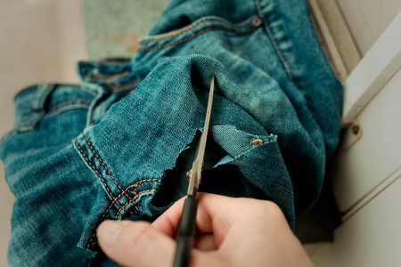 Sawing and cutting jeansの写真素材