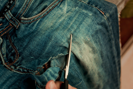 Sawing and cutting jeansの写真素材