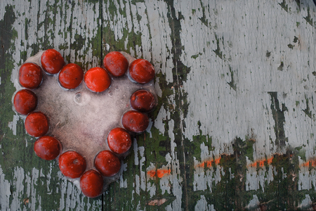 Ice heart from cherry on a white old background. The concept of not shared loveの写真素材