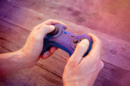Blue joystick gamepad, game console on wooden background.の写真素材