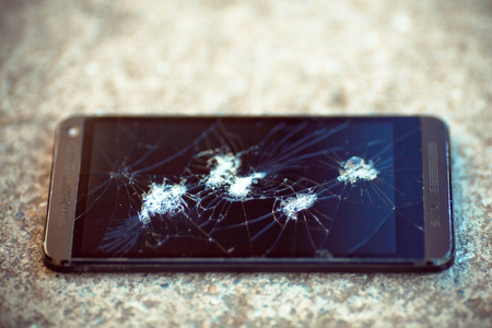 The broken phone screen on asphalt.の写真素材