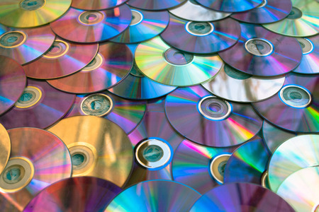 Background on the wall with old damaged discs cd.の写真素材