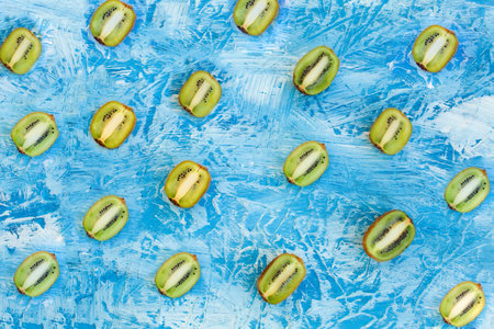 The cut kiwis on an abstract blue background.