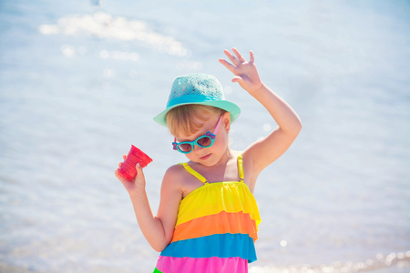 Girl eating ice cream in a hat and on the beachの写真素材