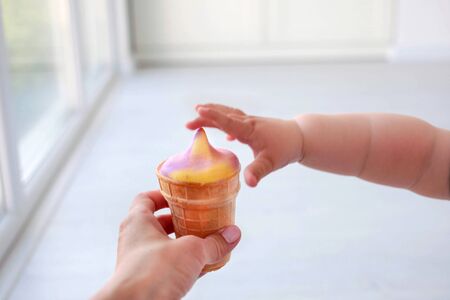 The children is hand reaches for ice creamの写真素材