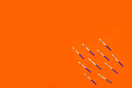 The test of a strip for pregnancy with negative result on an orange background. The place for the...