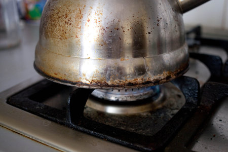 Dirty old dishes on a dirty gas stove, side view.