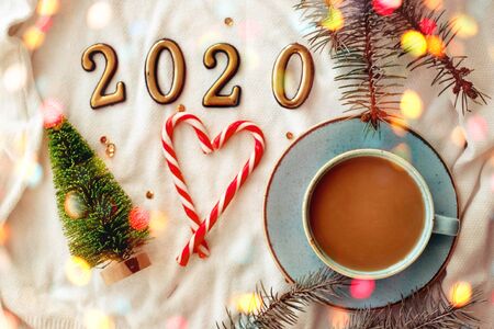 Blue cup with cappuccino in the New Year decoration, numbers 2020 and a heart made of sweets. New Year 2020, bokeh.の写真素材