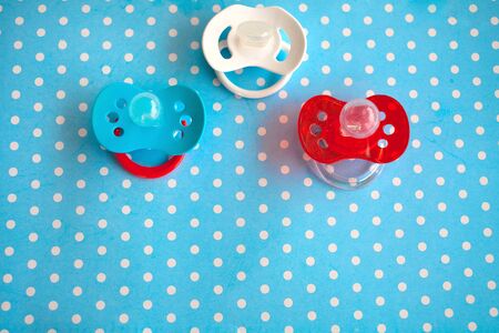 Three of babies silicone dummies pacifier on a blue background. Copy space.の写真素材