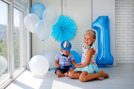 Brother and sister celebrate a birthday. 1 year old, decorations, balloons.の写真素材