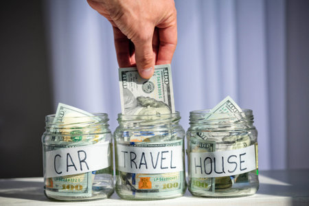 Male hand puts 100 dollars in a glass jar with the inscription travel.Concept of saving money.