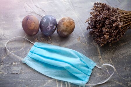 Easter eggs and medina mask on a gray background. Quarantine, stay home concept.の写真素材