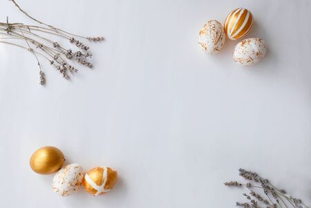 Top view Easter eggs painted with gold paint in various patterns on the sides of lavender. White background. Space for copy.の写真素材
