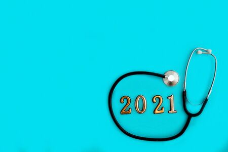 Stethoscope with 2021 number on blue background. Happy New Year for health care and medical banner/calendar cover. Top view , copy space. Medicine treatment and diagnosis concept.の写真素材