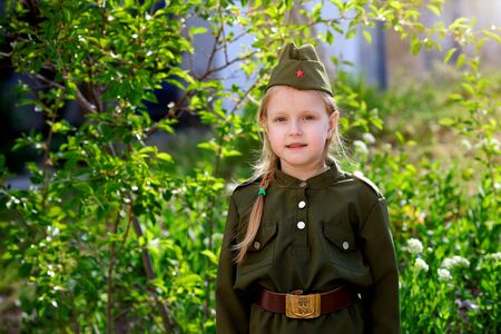 Portrait of a girl in uniform on a green background. Victory Day, May 9 holiday.の写真素材