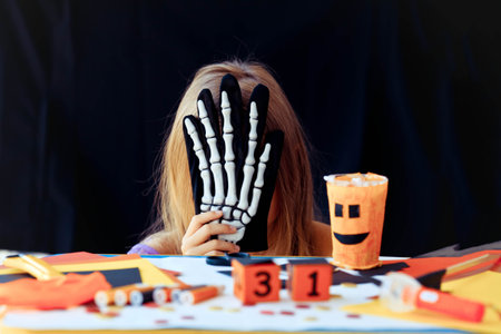 A little girl holds on her head a wooden calendar with the date of October 31. Halloween holiday...